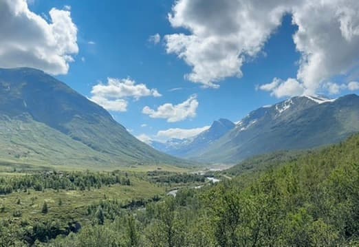 Green valley between mountains under a blue sky