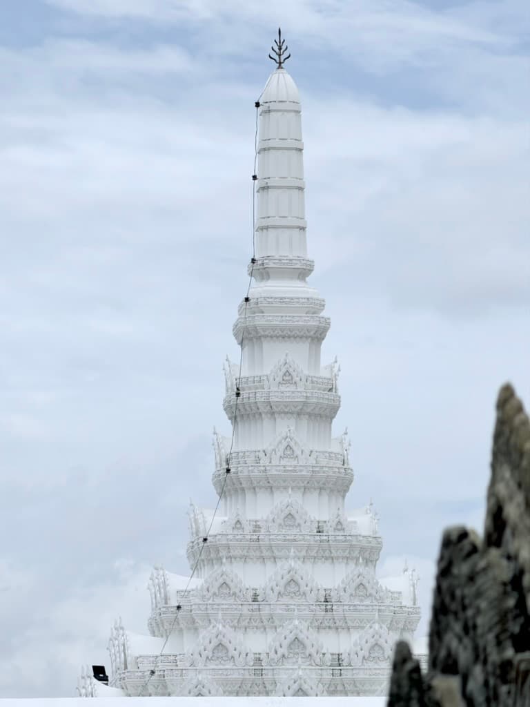 White temple spire against a cloudy sky